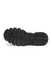Semelle extérieure en caoutchouc noir avec des motifs de crampons profonds et des lugs multidirectionnels pour l'adhérence ; présente un intercalaire marron et un bord texturé.