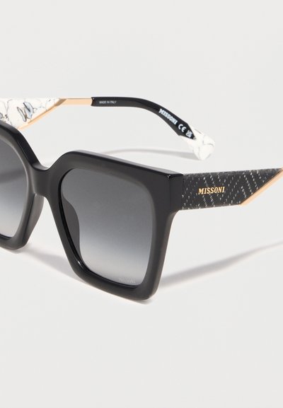 Μεγάλα τετράγωνα μαύρα γυαλιά ηλίου με φακούς σε διαβάθμιση γκρι, βραχίονες με χρυσές διακριτικές λεπτομέρειες και λογότυπο "MISSONI" στα πλάγια.