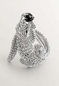 Anillo de plata en forma de cocodrilo con escamas texturizadas y un acento de gema negra en su boca. Detallado e intrincadamente diseñado.