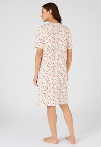 Vestido de noche de manga corta en tela suave con un estampado floral en rosa, amarillo, verde y azul sobre un fondo crema; diseño hasta la rodilla.