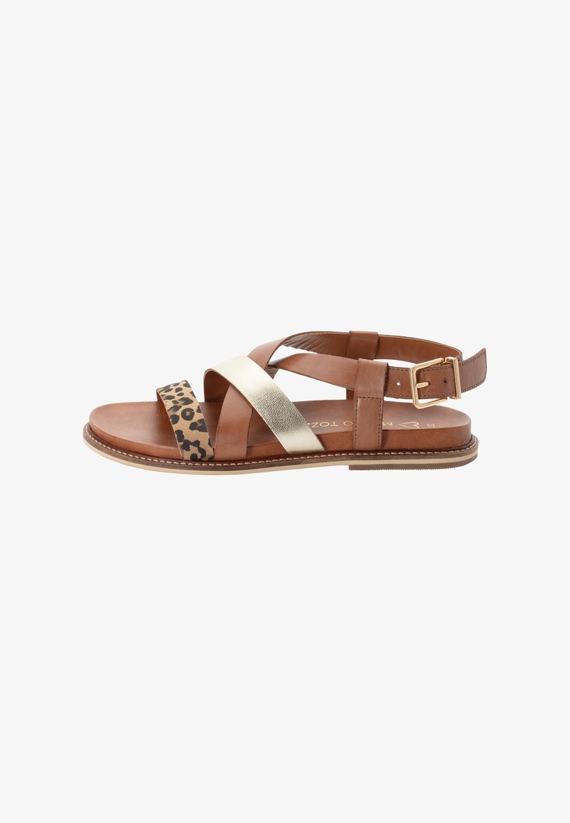 Sandale en cuir marron avec imprimé léopard, brides dorées métalliques et boucle dorée sur semelle plate, sur fond blanc.