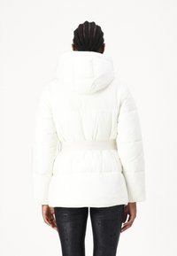 Hvid pufferjakke med hætte, indsnævret talje og lange ærmer. Struktureret stof med en glat overflade og diskret branding på bæltet.