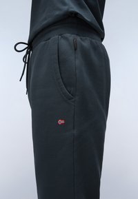 Donkergrijze sweatpants van zacht katoen, met een elastische tailleband, verstelbaar trekkoord, zijzakken en een klein Noors vlagpatch.