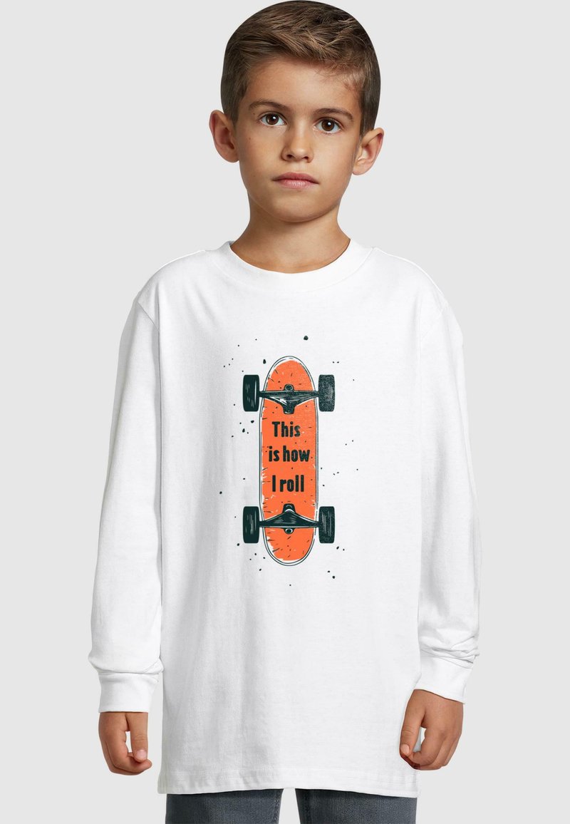 Langærmet hvid skjorte med et orange skateboardgrafik med sorte hjul og teksten "Sådan ruller jeg" i sort på fronten.