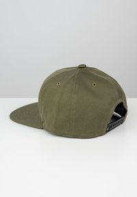 Olijfgroene baseballcap met een vlakke klep, textuurstof, verstelbare snapback-sluiting en ventilatie-oogjes aan de achterkant.