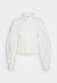 Hvid cropped skjorte med krave, smocked frontdetalje og puffede ærmer. Har en flæsekant og traditionel knaplukning.