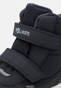 Fekete fiúcipő, puha textil felsőrésszel, tépőzárral és megerősített lábujjal. Szürke kiegészítő található a talpon és plüss bélés biztosítja a kényelmet.