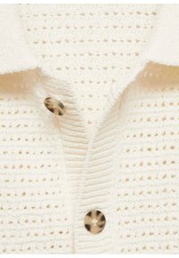 Cardigan bianco lavorato a maglia con un tessuto testurizzato, colletto a punte e un singolo bottone rotondo in tartaruga al collo.