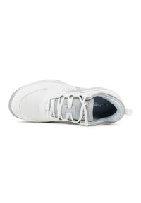 Zapatilla deportiva blanca con parte superior de malla, acentos grises, suela de goma texturizada y lengüeta acolchada. Presenta perforaciones para la transpirabilidad.