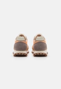 Takapuolet kengät, joissa on beige ja oranssi verkkokangas ja mokka, valkoinen välikerros ja teksturoitu kumipohja.