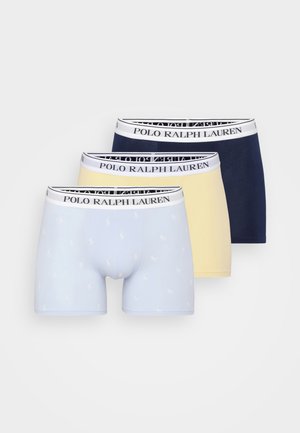 Trois paires de boxers : bleu clair à motifs, jaune et marine. Chacune a une ceinture blanche avec "POLO RALPH LAUREN" imprimé.