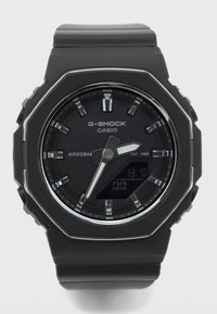Czarny zegarek G-SHOCK z ośmiokątną kopertą, wyświetlaczem analogowo-cyfrowym, dużymi oznaczeniami godzin oraz teksturowanym silikonowym paskiem. Wodoodporność WR20BAR.