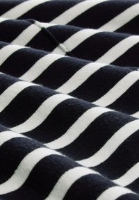 Marineblauer Stoff mit wellenförmigen weißen Streifen, der eine weiche Textur und ein auffälliges horizontales Muster aufweist. Das Material scheint gestrickt zu sein.