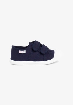 Pantofii din pânză de marină, cu două curele cu arici, vârf din cauciuc alb și un material texturat având o etichetă cu logo pe lateral.