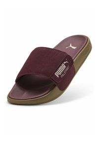 Maronde ruskinds-sandaler med brede stropper, der har hvid branding på siden og en tekstureret brun gummisål.