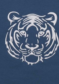 Volto di tigre bianca con strisce dettagliate su uno sfondo di tessuto blu, centrato e simmetrico.