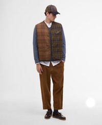 Padded checkered kamizelka w brązowym kolorze, niebieska bluzka z długim rękawem, jasnobrązowe spodnie z korduroju i ciemne buty sznurowane. Zawiera czapkę z akcentami w kratkę.