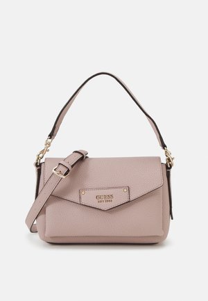 Sac à bandoulière en cuir texturé rose clair avec rabat à fermeture, ferrures dorées, sangle réglable et inscription "GUESS EST 1981" embossée à l'avant.