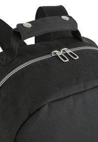 Zaino nero realizzato in tessuto resistente, con zip argento a doppio cursore e una maniglia in canvas sulla parte superiore con chiusure metalliche per un trasporto sicuro.