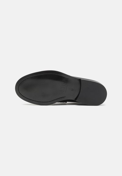Schwarze Schuhsohle mit glatter Oberfläche, runder Form und subtil geprägtem Logo. Verfügt über eine Naht entlang des Randes und ein minimalistisches Design.