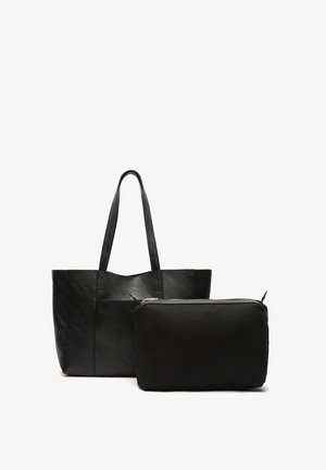 Mustan nahkainen laukku, jossa on teksturoidun pinnan ja kaksi kantohihnaa, mukana pieni musta vetoketjullinen pussi, joka on valmistettu sileästä kankaasta.