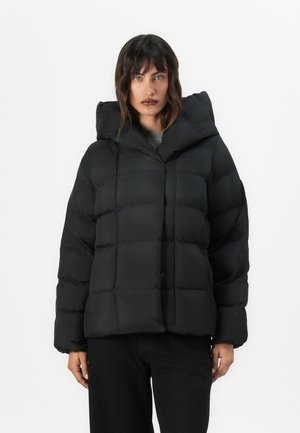 Giubbotto imbottito nero con cappuccio grande, design trapuntato e forma squadrata. Presenta polsini larghi e chiusura frontale a scatto. Texture opaca.