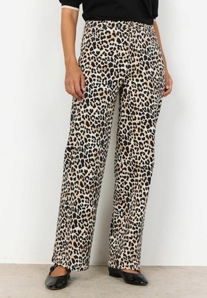 Pantalons à jambes larges en imprimé léopard, fabriqués en tissu doux ; présentant un fond beige avec des taches noires. Assortis à des chaussures plates noires.
