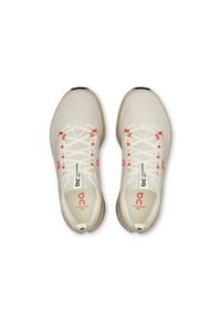 Lightweight running shoes featuring a beige mesh upper with red accents, a cushioned sole, and flat, white laces. Logo on the side.