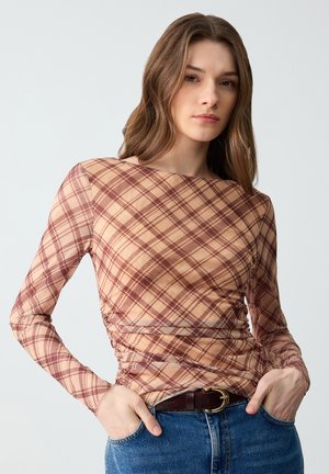 Langsleeve, pasvormtop van doorschijnende stof met een tan en bordeaux ruitpatroon. Beschikt over een ronde halslijn en geplooide details aan de zijkanten.