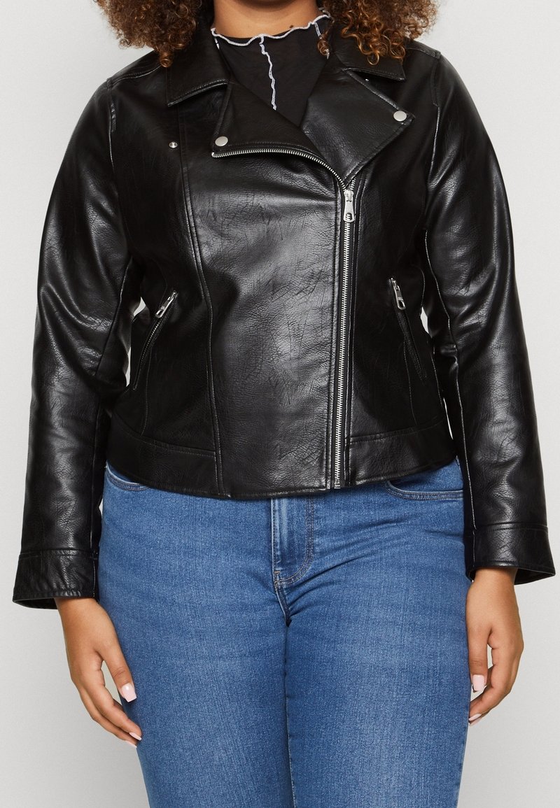 Svart lädermotorcykeljacka med blixtlåsfickor, silverfärgad hårdvara och med en urskuren krage; bärs över en svart topp och blåjeans.