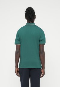 Πράσινο βαμβακερό πόλο πουκάμισο με ριμπ γιακά και μανσέτες στα μανίκια, με απλό σχέδιο και ευθεία ραφή στο τελείωμα.