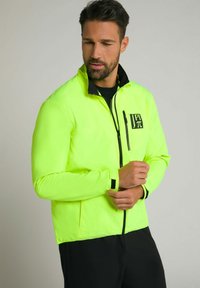 Neon-gelbe leichte Jacke mit schwarzem Kragen, Reißverschluss-Brusttasche und kontrastierenden schwarzen Akzenten an den Bündchen.