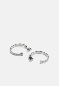 Orecchini a cerchio in argento con un design intrecciato, caratterizzati da un accento con logo quadrato e dettaglio floreale alla chiusura.