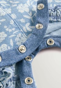 Denimtøj med lyseblåt blomsterprint, udstyret med metaltryklåse og blød tekstur. Samlet detaljer langs kanterne for at forbedre pasformen.