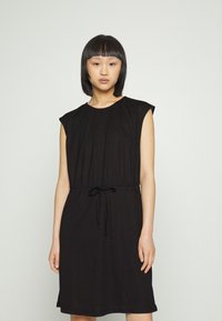 Vestido preto até ao joelho, feito de um tecido suave, com mangas curtas, cintura elástica e detalhe de cordão no cós. Textura lisa.