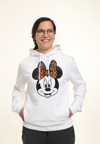 Sudadera blanca con la cara de un personaje de dibujos animados negro y un gran lazo de estampado de leopardo. Fabricada en algodón, con bolsillos frontales y cordones.