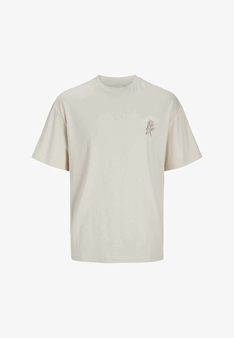 Camiseta de algodón beige con mangas cortas y cuello redondo. Presenta un pequeño gráfico floral en azul y púrpura en el área del lado izquierdo del pecho.