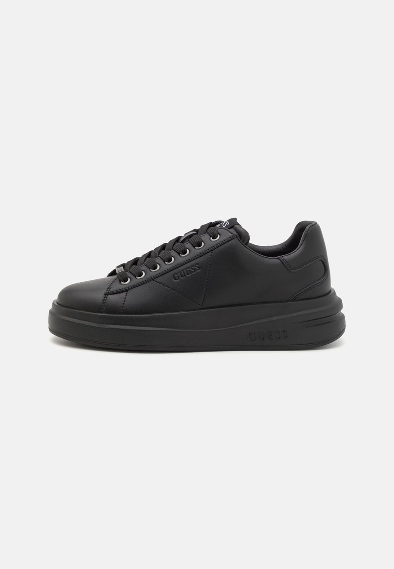 Baskets basses noires avec semelle épaisse, lacets sur le devant et logo Guess embossé sur le côté et la semelle.