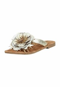 Sandale plate avec semelle marron, bride dorée et grande décoration florale métallique superposée sur le dessus.