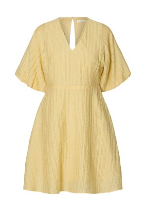 Robe courte jaune texturée avec larges manches courtes, décolleté en V, et légère évasement à la taille pour une coupe décontractée.