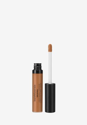 Flüssiger mineralischer Concealer in einem klaren Röhrchen mit schwarzem Deckel. Brauner Applikator mit runder Spitze. Etiketten in Schwarz auf dem Röhrenkörper.