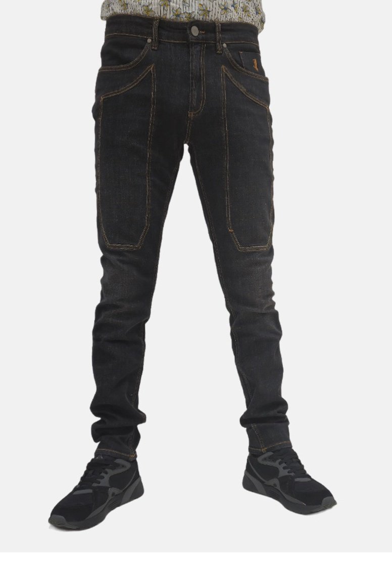 Jeans in denim scuro con una vestibilità slim, caratterizzati da cuciture a contrasto, tasche frontali e una piccola patch con logo. Abbinati a sneakers nere.