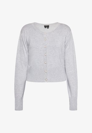 Šviesiai pilkas megztinis su ilgomis rankovėmis, apvalia iškirpte ir trumpa forma. Priekinėje dalyje yra šeši dekoratyviniai mygtukai. Minkšta medžiagos tekstūra.