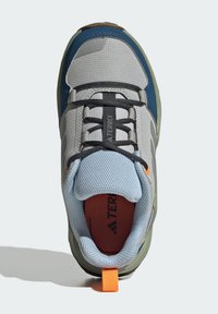 Grå og blå atletiksko med tekstureret mesh-overdel, sorte snørebånd, orange accenter og en grøn gummisål, udstyret med en træktab ved hælen.