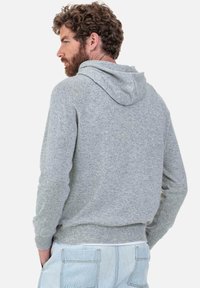 Sweat à capuche gris en tissu doux, avec une coupe décontractée, des poignets en côtes et une poche kangourou à l'avant.