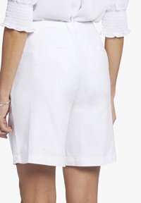 Witte linnen shorts met een rechte snit, met een gladde textuur en twee achterzakken. De zoomafwerkingen zijn schoon en gelijkmatig.