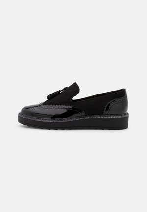 Mocassins noirs avec une finition laquée brillante, une tige en tissu texturé et une semelle légèrement compensée avec un accent scintillant.