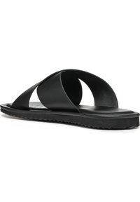 Sandale en caoutchouc noir avec un semelle moulée, deux brides croisées et une semelle texturée pour une meilleure adhérence. Design minimaliste avec finition lisse.