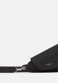 Czarna torba na ramię wykonana z gładkiego materiału z klapą. Posiada metalową zapięcie i akcent logo. Idealna do codziennego użytku.