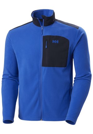 Niebieska polarowa kurtka z czarną zamykaną na zamek kieszenią na piersi, wysokim kołnierzem i kontrastowymi czarnymi panelami na ramionach. Zawiera subtelne detale logo.